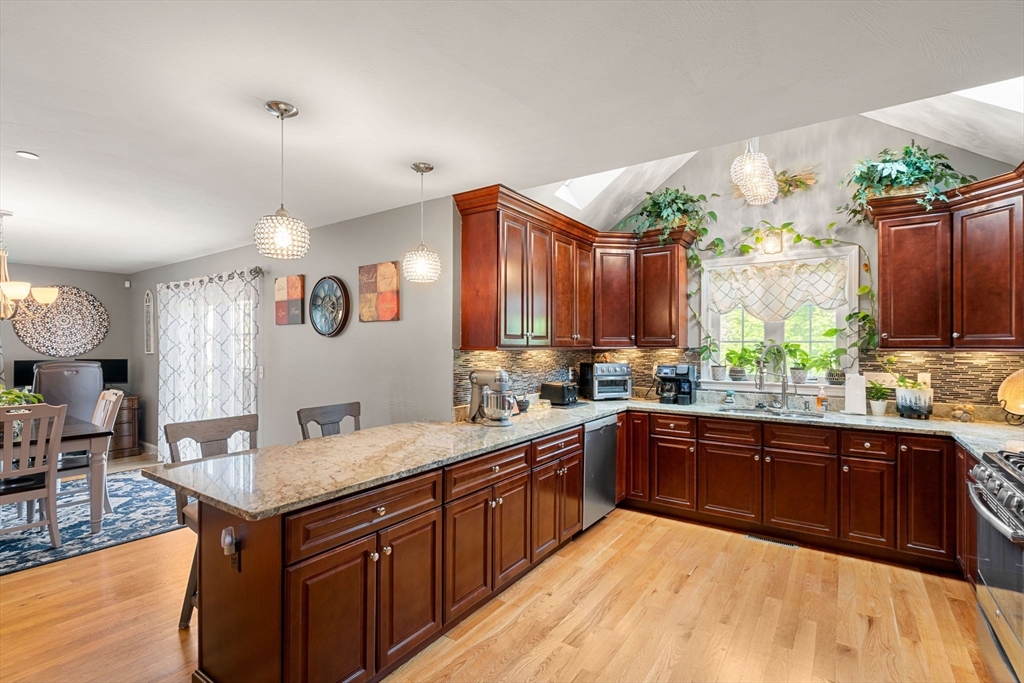 5 Comanche Circle, Unit 5 Haverhill, MA 01835 - Photo 5 of 29 a kitchen with stainless steel appliances granite countertop a sink a stove and a wooden floors