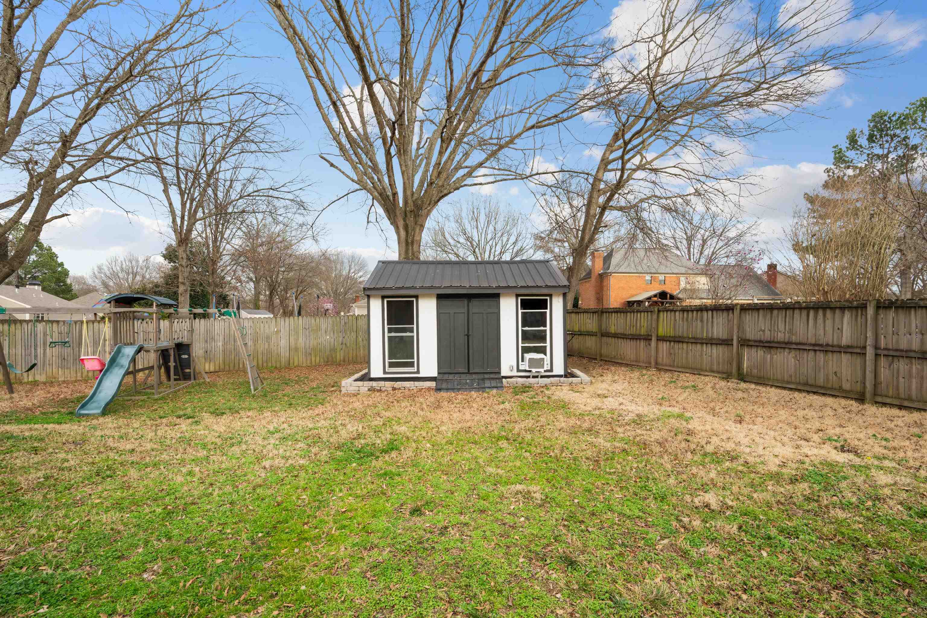 608 King Ridge Cove Collierville, TN 38017 - Photo 29 of 32 Fenced backyard featuring a storage unit and a playground.
