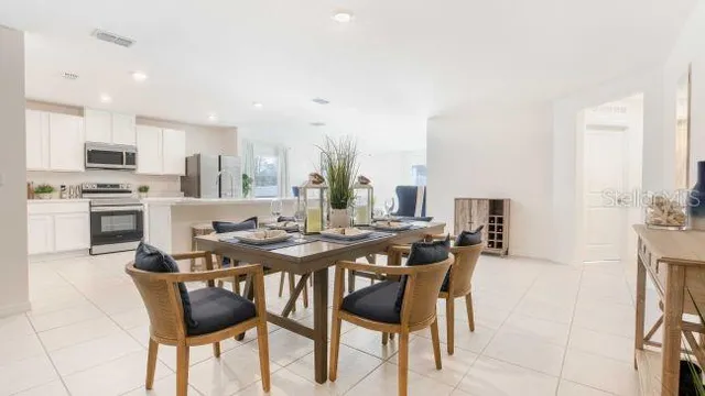 a dining room with furniture and kitchen view