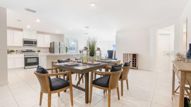 488 North Corbin Avenue Inverness, FL 34453 - Photo 6 of 16 a dining hall with stainless steel appliances kitchen island granite countertop a table chairs and a refrigerator