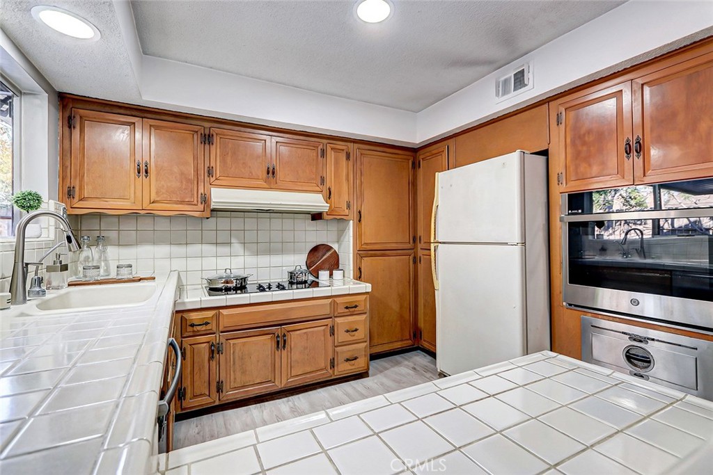 2861 Channing Way Rossmoor, CA 90720 - Photo 13 of 39 a kitchen with stainless steel appliances a refrigerator sink and cabinets