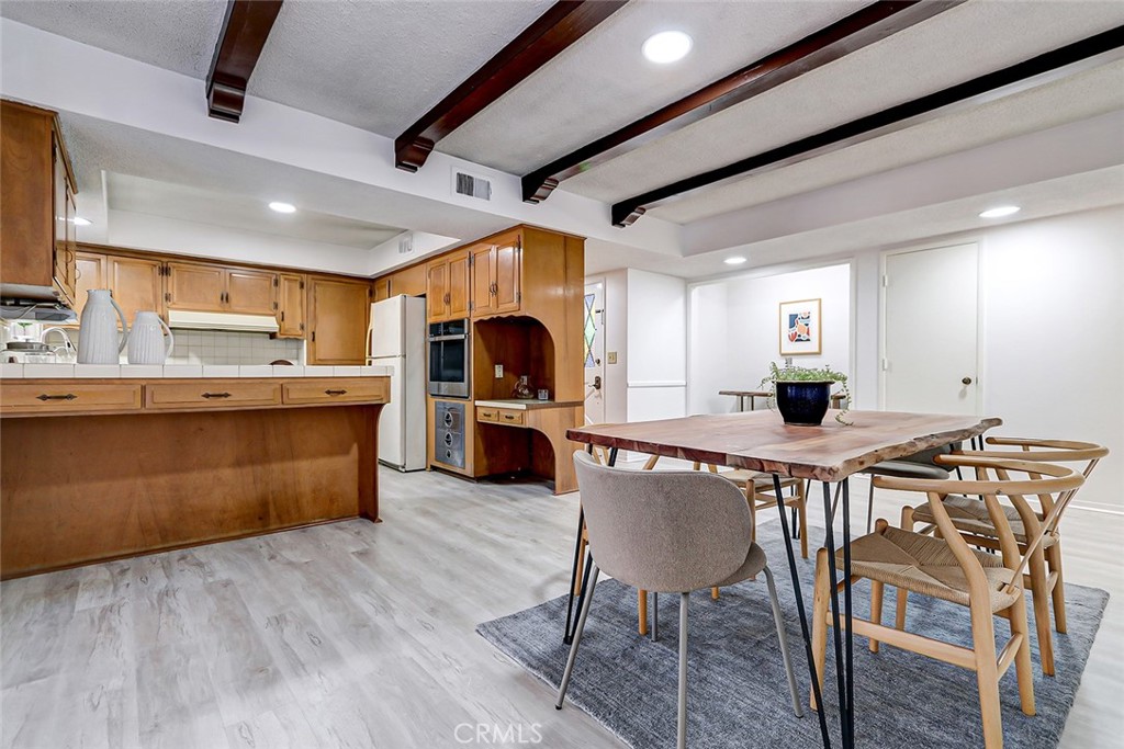 2861 Channing Way Rossmoor, CA 90720 - Photo 10 of 39 a kitchen with stainless steel appliances kitchen island granite countertop a table chairs sink and cabinets