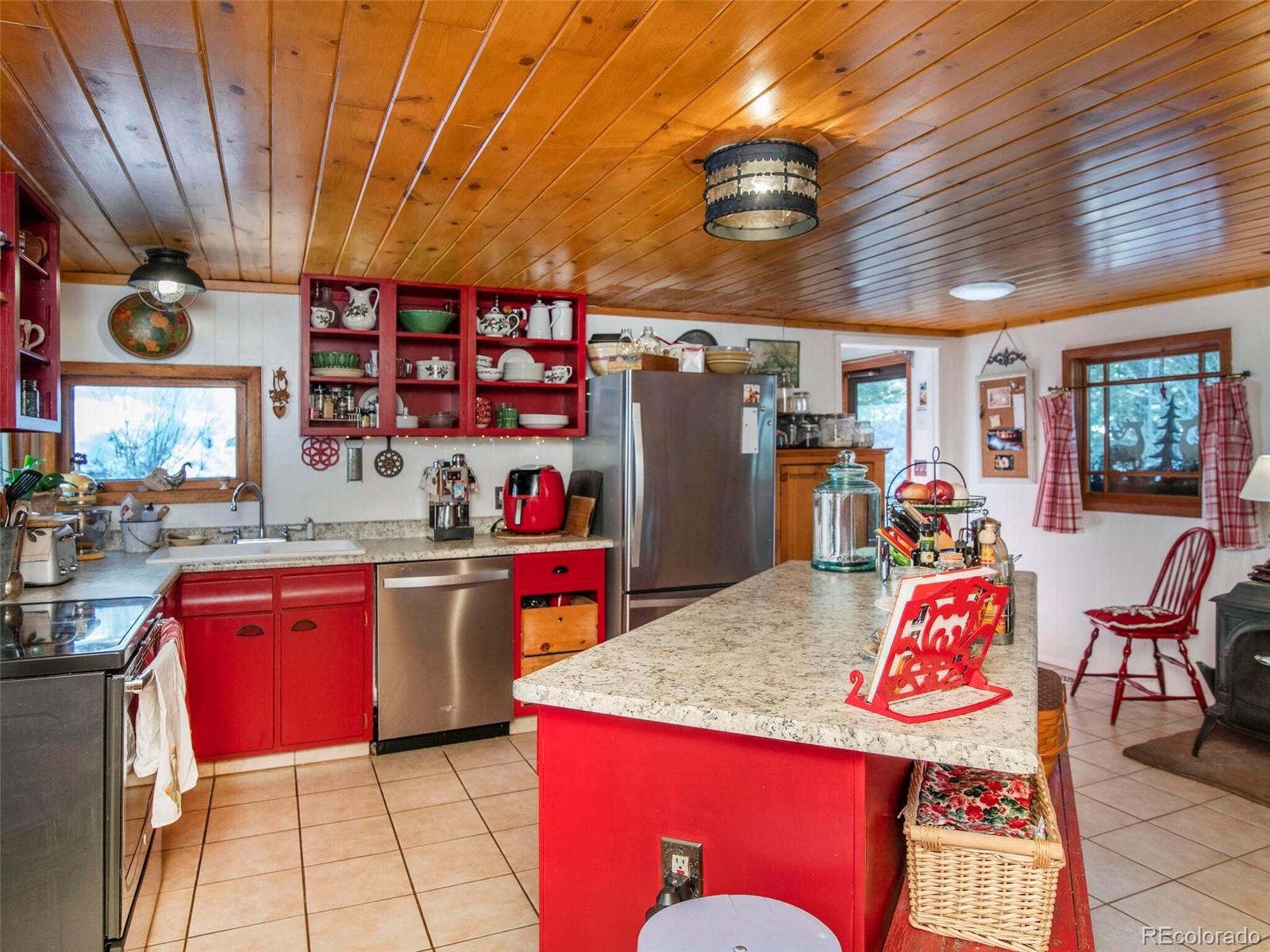 3135 Riverside Drive Lyons, CO 80540 - Photo 11 of 37 a kitchen with stainless steel appliances granite countertop a sink dishwasher and a refrigerator with wooden floor