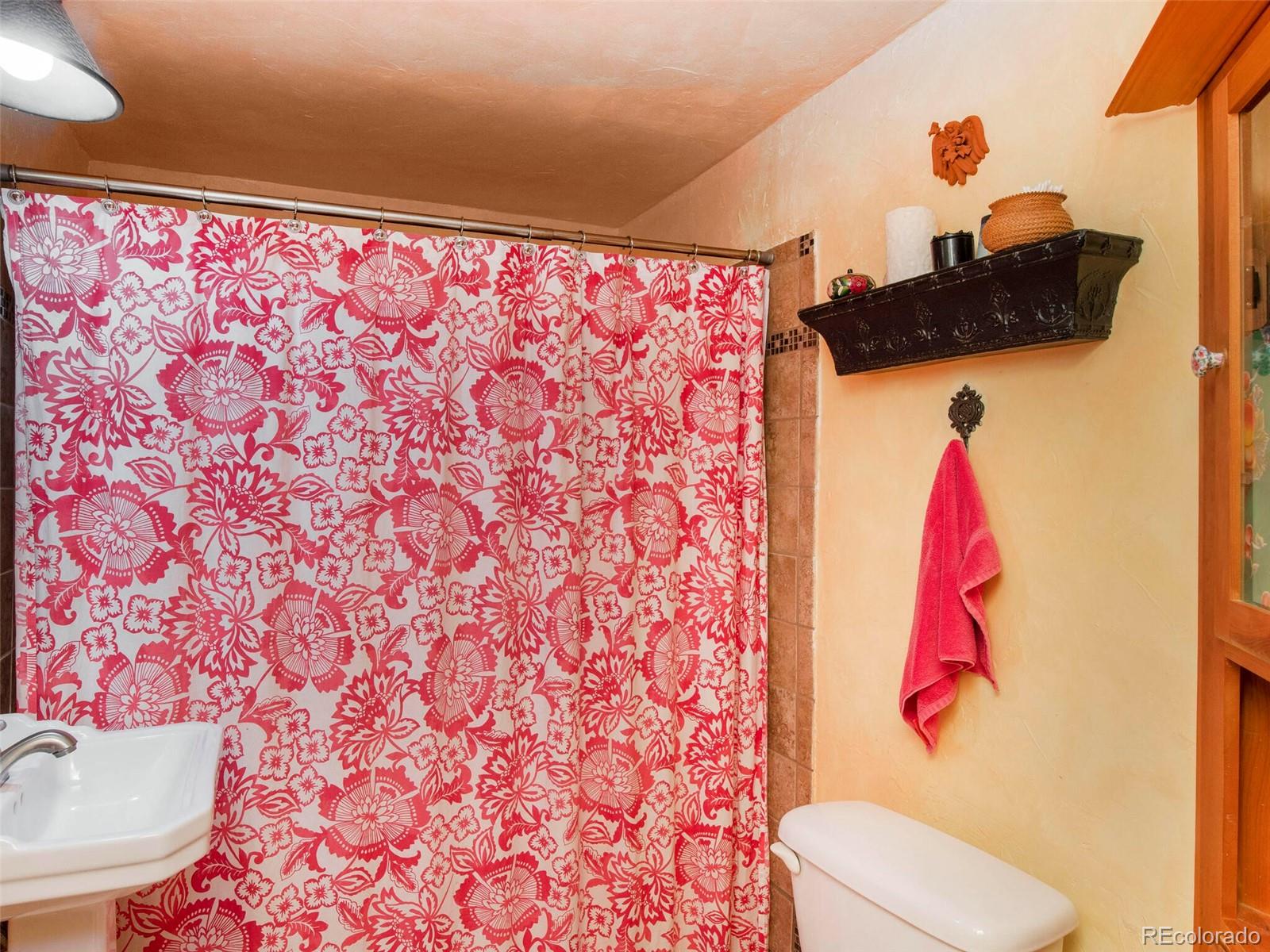 3135 Riverside Drive Lyons, CO 80540 - Photo 15 of 37 a bathroom with a sink toilet and a shower curtain