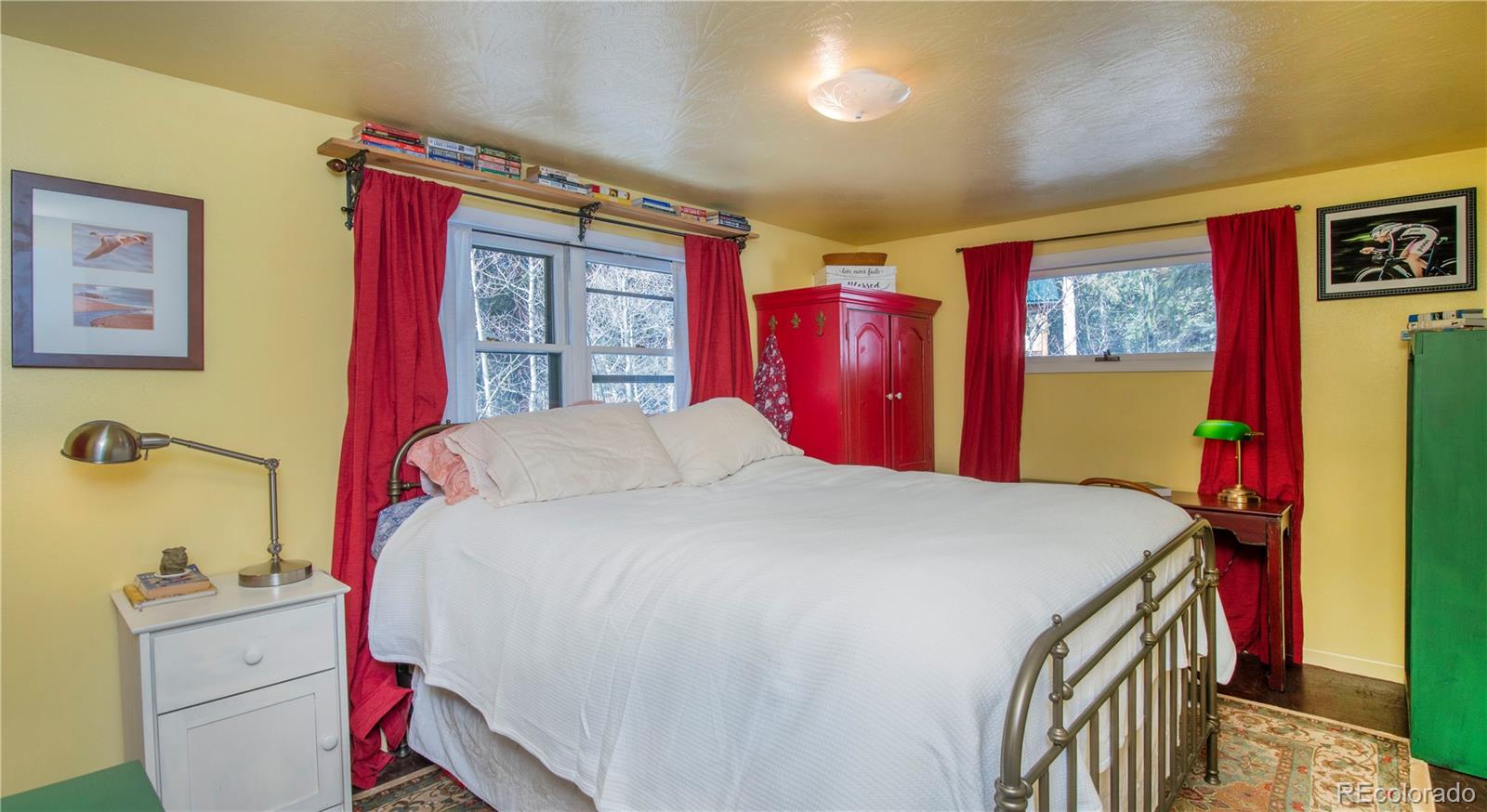 3135 Riverside Drive Lyons, CO 80540 - Photo 22 of 37 a bedroom with a bed and a dresser next to a window