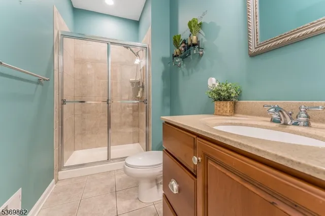 a bathroom with a granite countertop sink a toilet and shower