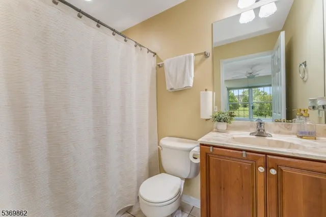 a bathroom with a granite countertop sink toilet and a mirror