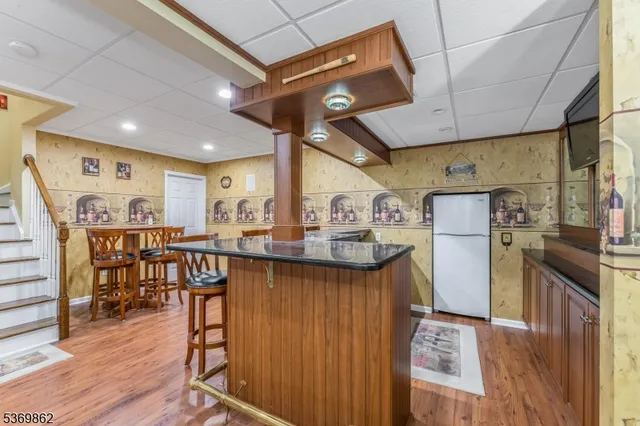 a kitchen with stainless steel appliances granite countertop a table chairs and wooden floor