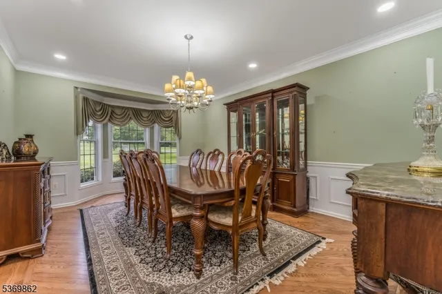 a dining room with furniture a chandelier and wooden floor