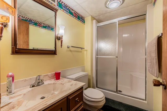 a view of a small yard with wooden fence and large trees