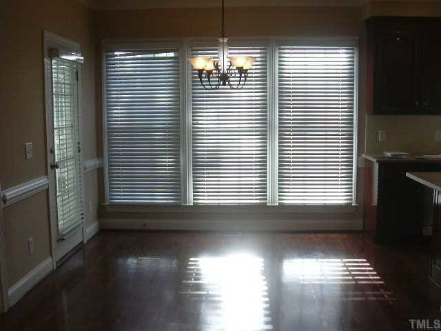 9420 Stone Mountain Road Raleigh, NC 27613 - Photo 5 of 12 a view of an empty room with wooden floor and a window