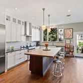 a kitchen with stainless steel appliances granite countertop a table chairs refrigerator and sink