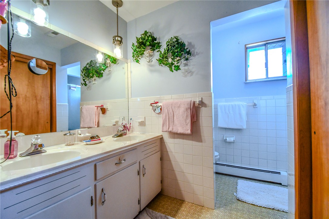 10833 Kendig Road Medway, OH 45341 - Photo 23 of 46 This bright bathroom features a spacious dual vanity and practical tiled surfaces.