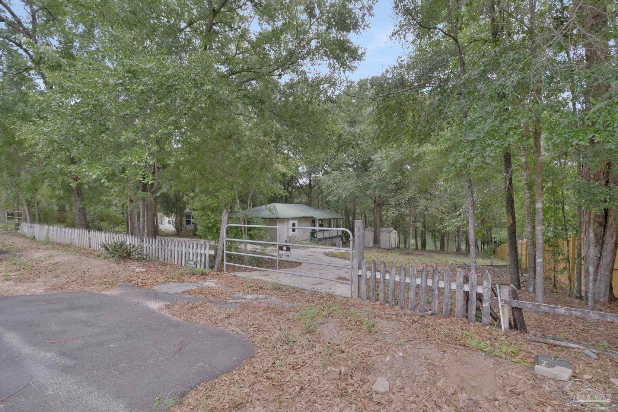 10290 West Lake Road Milton, FL 32583 - Photo 44 of 53 a view of a house with a backyard and trees