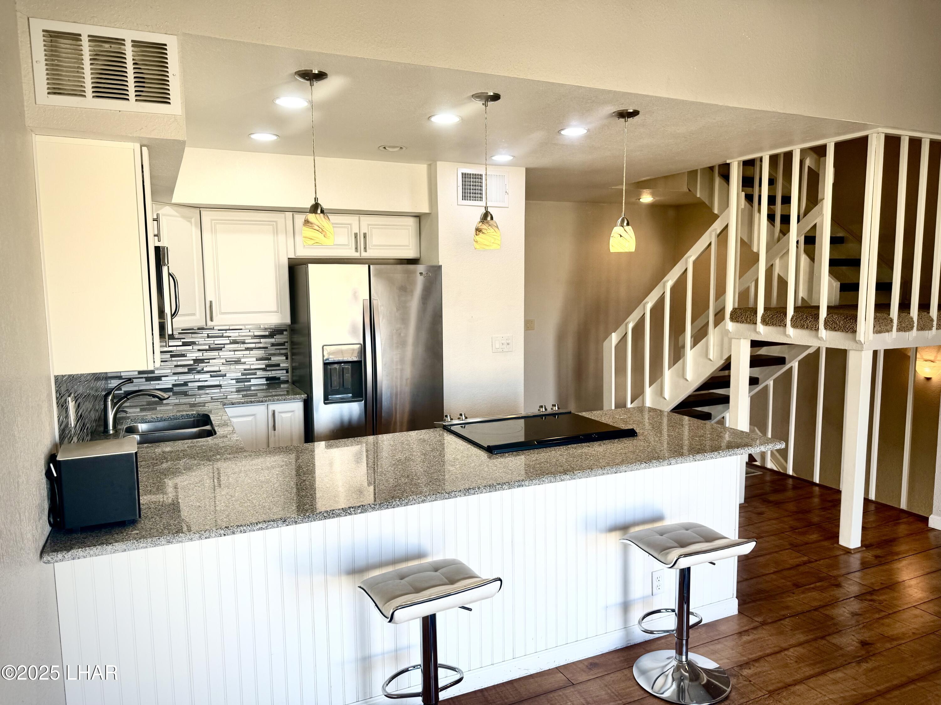 8625 Riverside Drive, Unit 38 Parker, AZ 85344 - Photo 12 of 48 a living room with stainless steel appliances kitchen island granite countertop a table chairs and a refrigerator