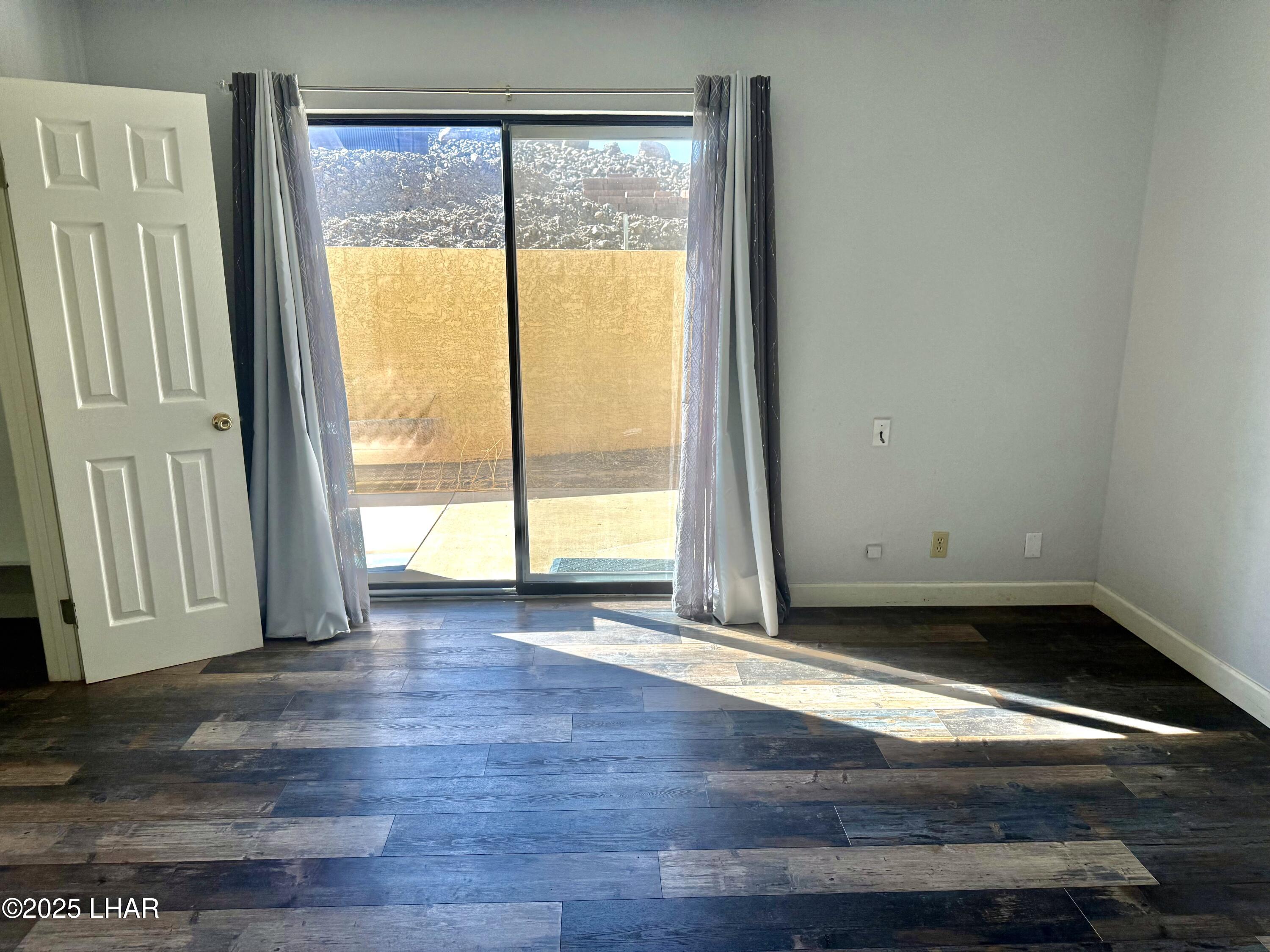 8625 Riverside Drive, Unit 38 Parker, AZ 85344 - Photo 17 of 48 a view of an empty room with wooden floor and a window