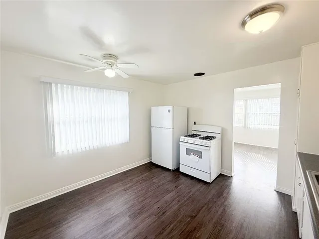 a kitchen with a stove a refrigerator and a stove with wooden floor