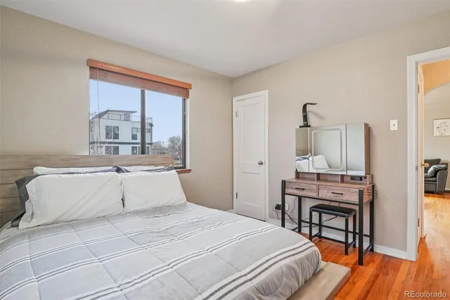 a bedroom with a large bed and a wooden floor