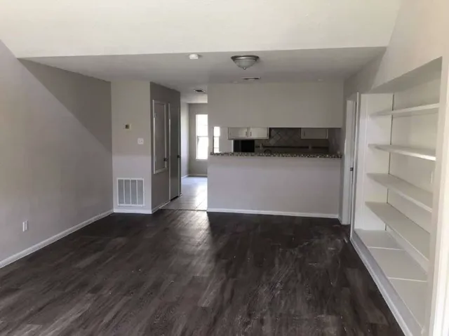 a view of empty room with wooden floor