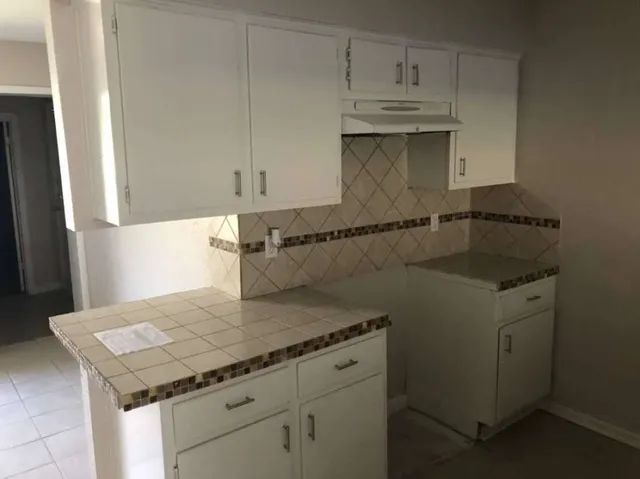 a kitchen with a sink cabinets and wooden floor