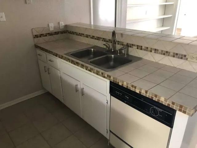 a close view of a stove a sink and dishwasher with wooden floor