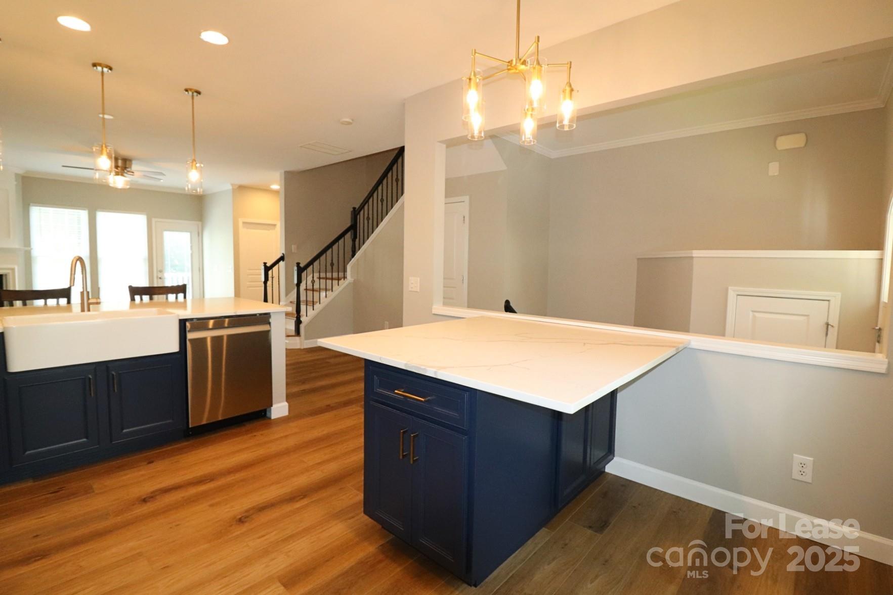 564 6th Baxter Crossing Fort Mill, SC 29708 - Photo 12 of 31 a kitchen with kitchen island a sink dishwasher a stove and a dining table with wooden floor