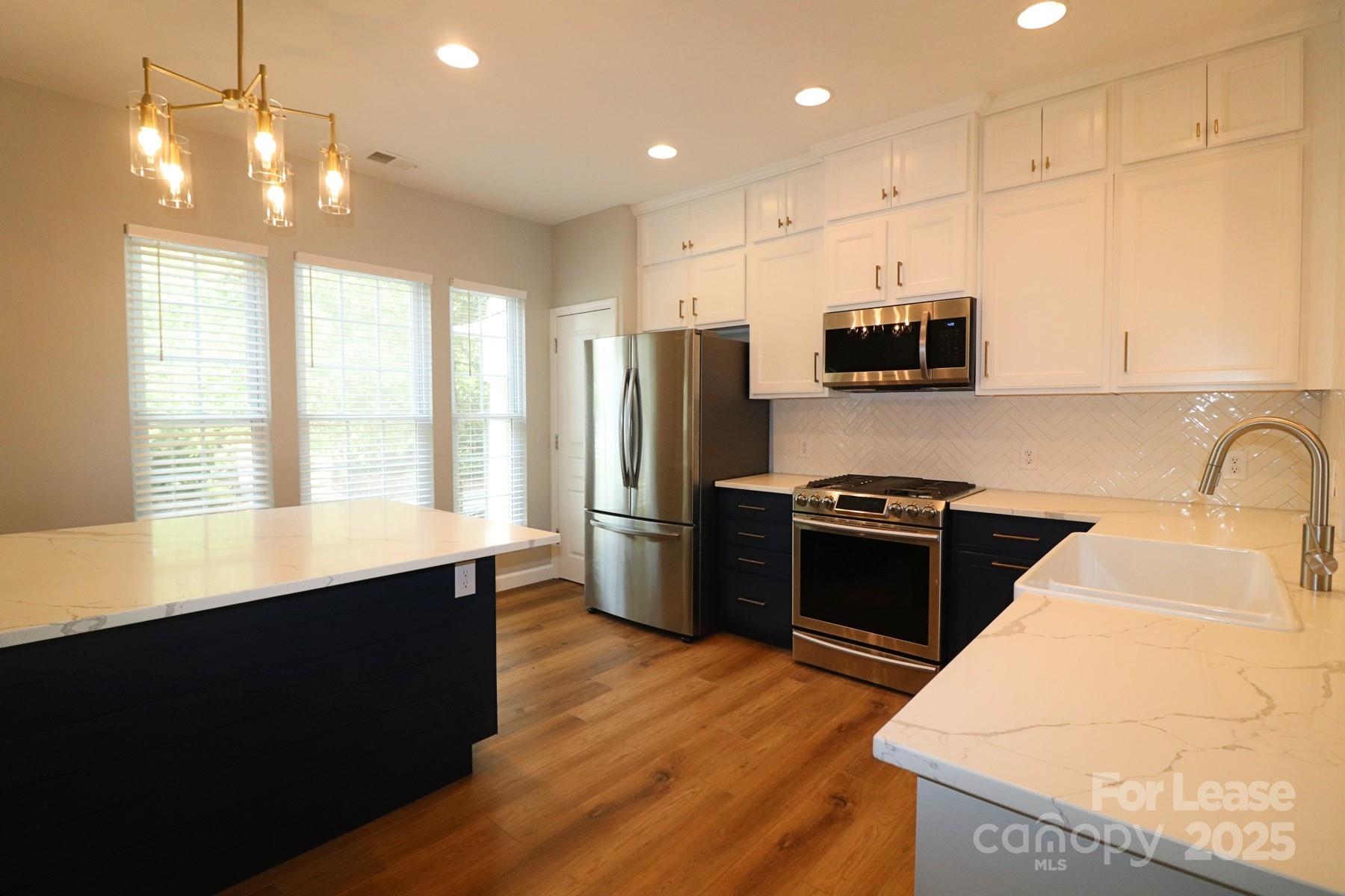 564 6th Baxter Crossing Fort Mill, SC 29708 - Photo 8 of 31 a kitchen with stainless steel appliances kitchen island granite countertop a stove a sink a refrigerator and a microwave