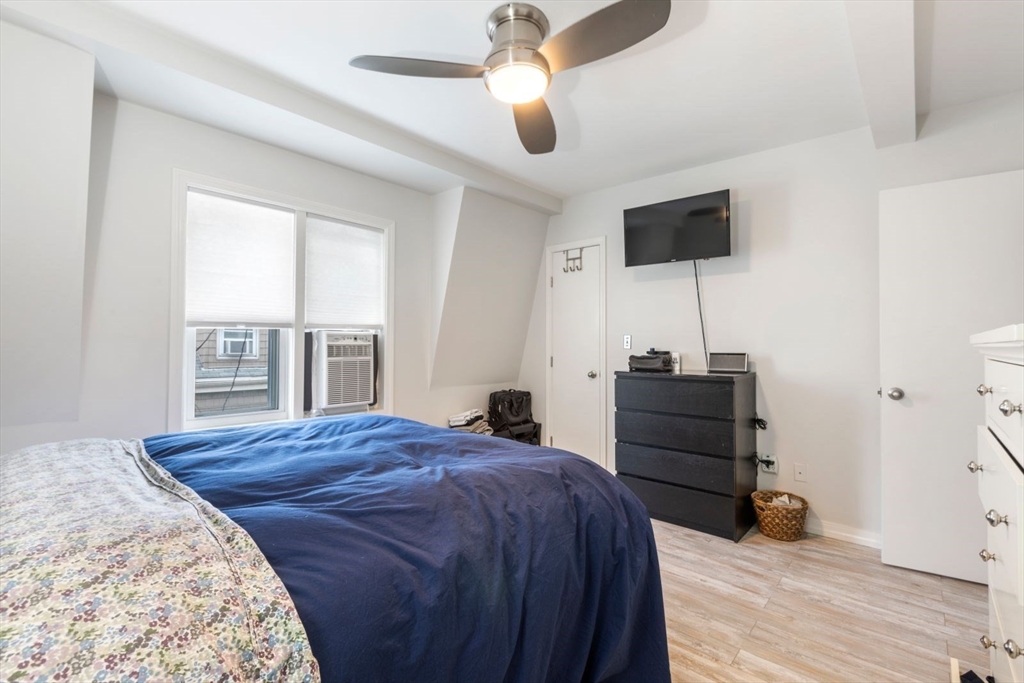 63 Bolton Street, Unit 63 Boston, MA 02127 - Photo 12 of 29 a bedroom with a bed and a flat tv screen on dresser