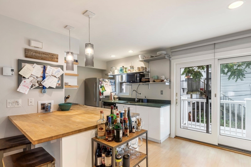 63 Bolton Street, Unit 63 Boston, MA 02127 - Photo 7 of 29 a kitchen with stainless steel appliances kitchen island granite countertop a refrigerator a stove top oven and a sink with garden view