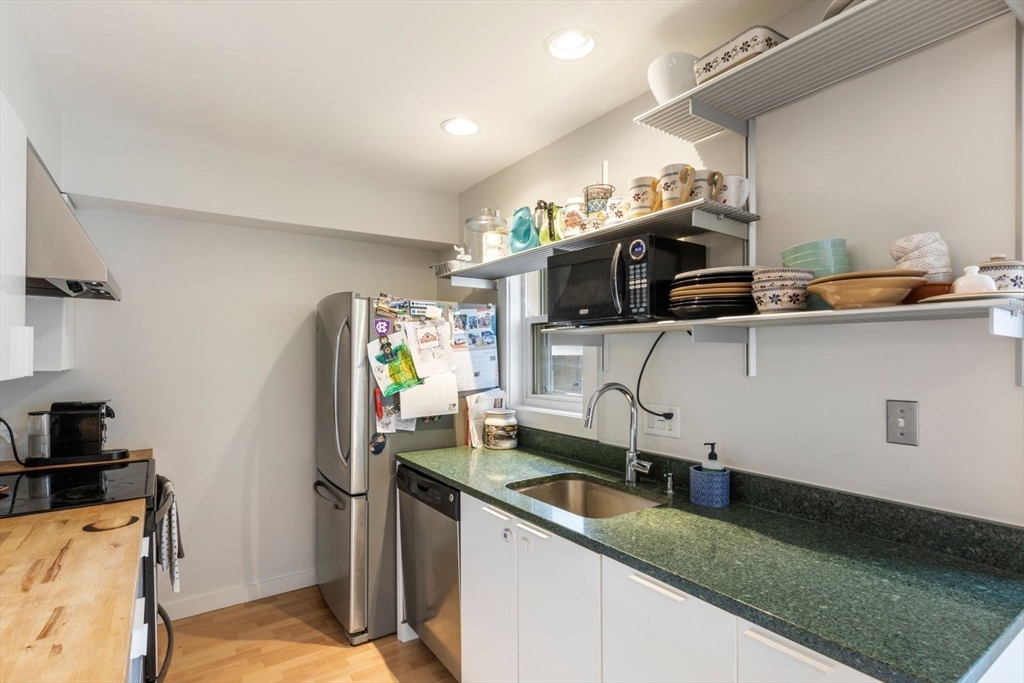 63 Bolton Street, Unit 63 Boston, MA 02127 - Photo 9 of 29 a kitchen with stainless steel appliances granite countertop a sink a stove and a refrigerator