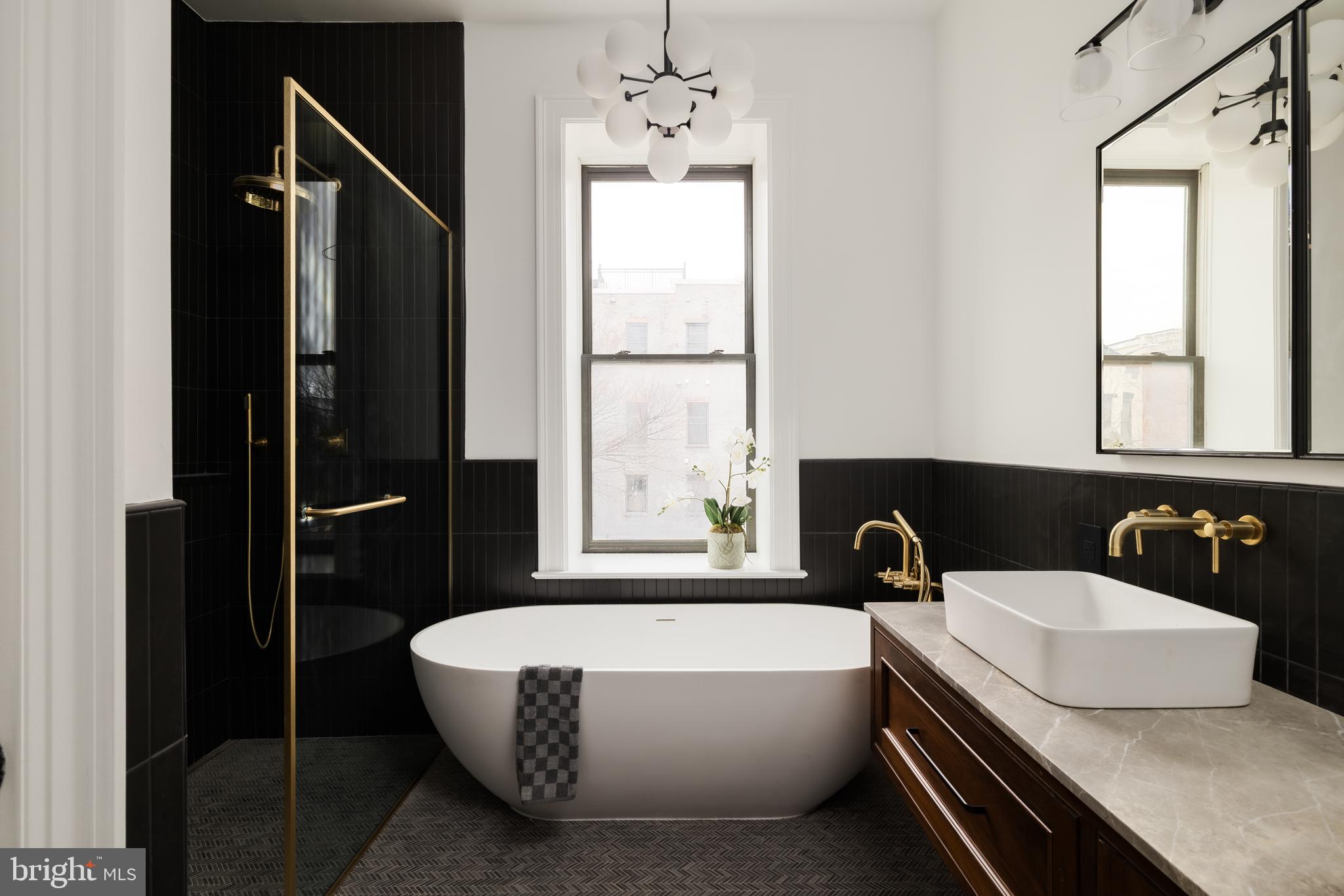 304 N Street Northwest, Unit 1 Washington, DC 20001 - Photo 31 of 47 a bathroom with a granite countertop sink a bathtub and window