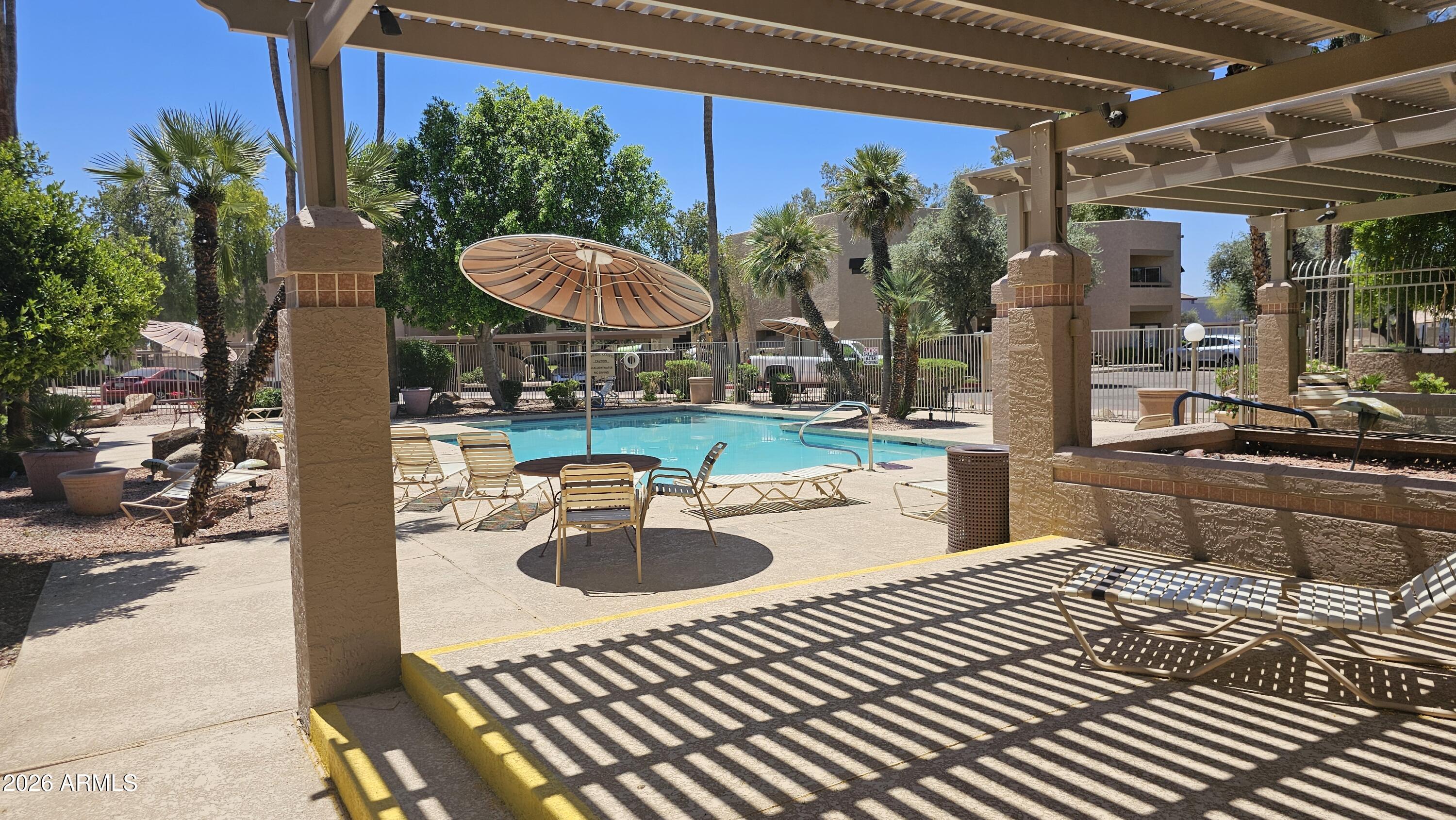 1287 North Alma School Road, Unit 282 Chandler, AZ 85224 - Photo 18 of 18 a view of a swimming pool with a patio and plants
