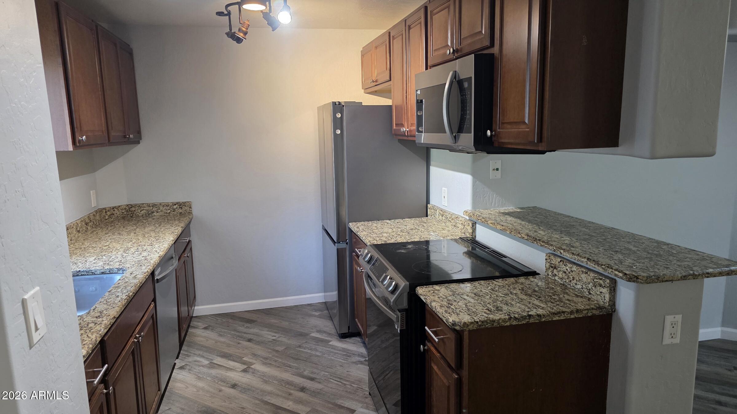 1287 North Alma School Road, Unit 282 Chandler, AZ 85224 - Photo 5 of 18 a kitchen with granite countertop a sink a stove and refrigerator