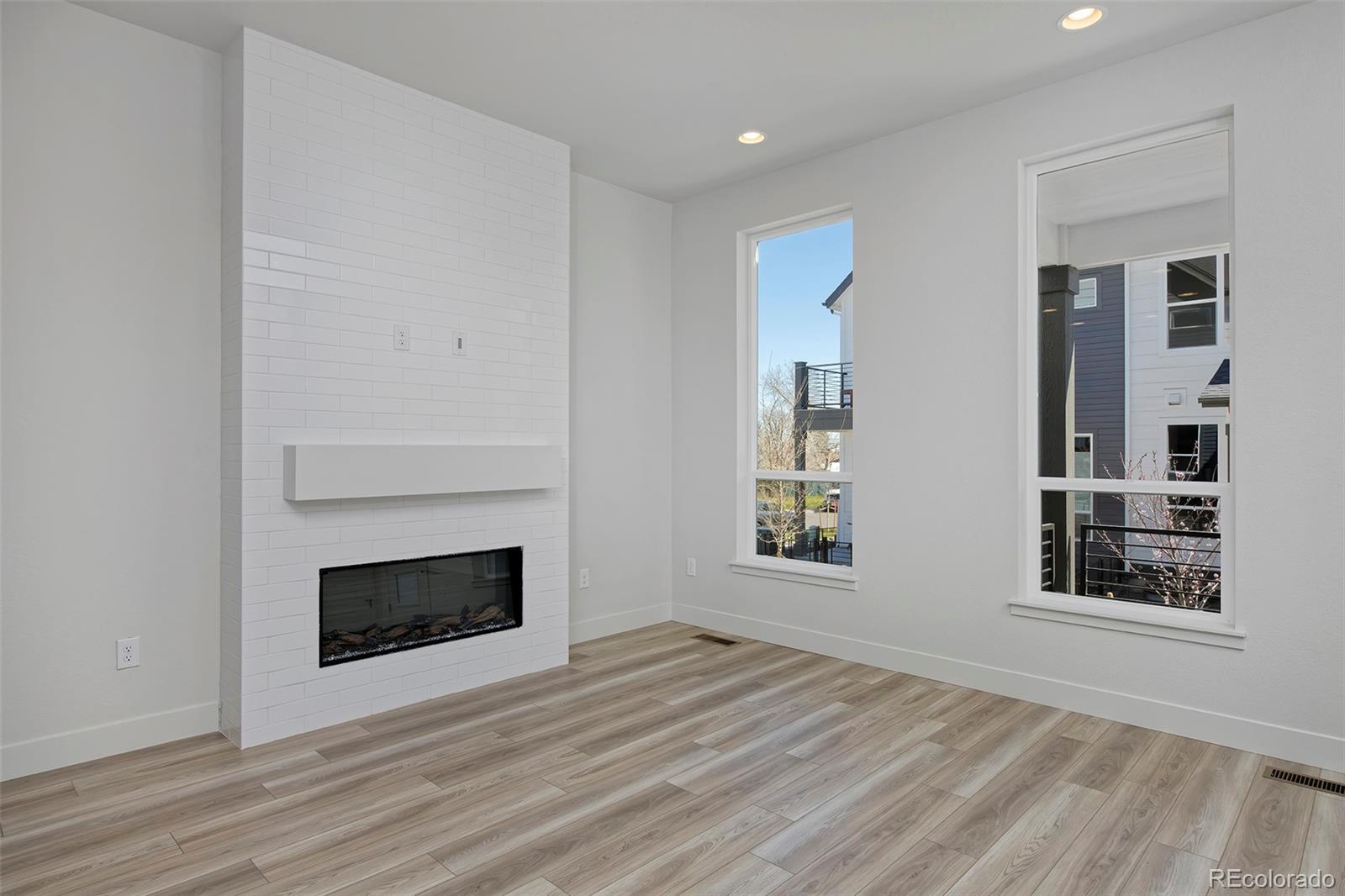 3136 West Bonfils Place Denver, CO 80236 - Photo 11 of 43 a view of an empty room with wooden floor fireplace and a window
