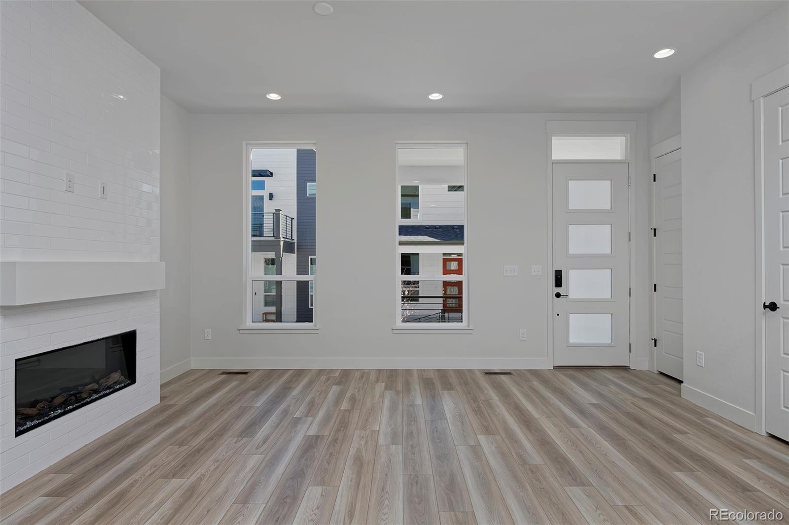 3136 West Bonfils Place Denver, CO 80236 - Photo 12 of 43 wooden floor in an empty room with a fireplace