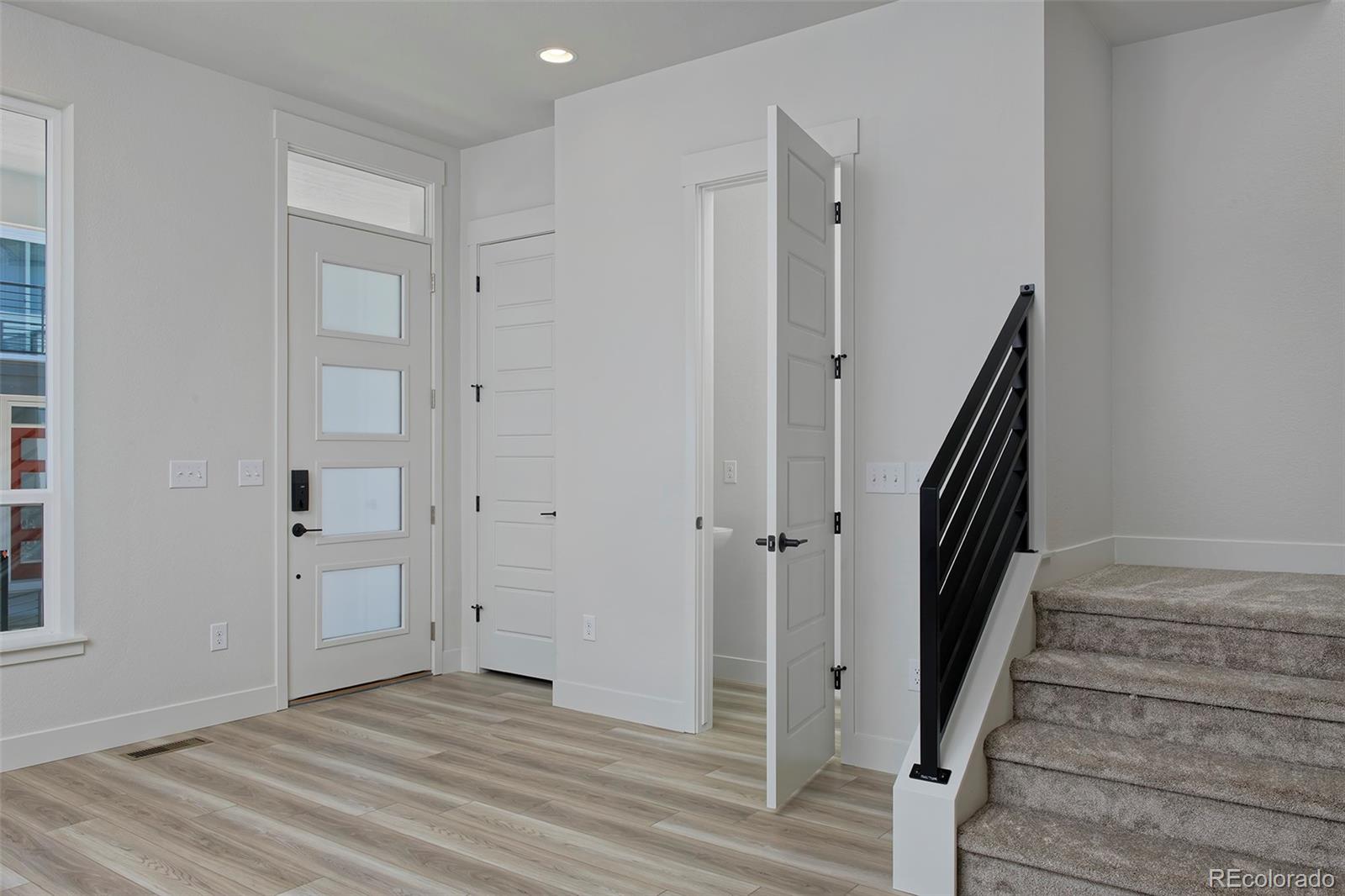 3136 West Bonfils Place Denver, CO 80236 - Photo 20 of 43 a view of a hallway with wooden floor and staircase