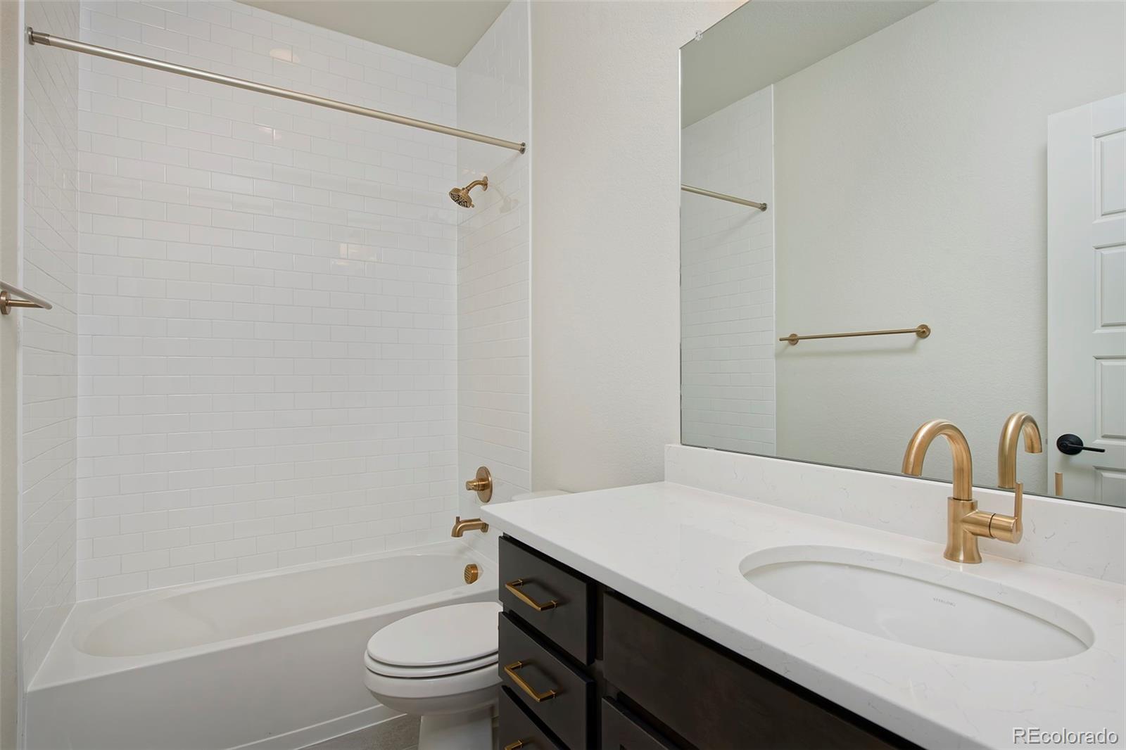 3136 West Bonfils Place Denver, CO 80236 - Photo 28 of 43 a bathroom with a sink a toilet and shower