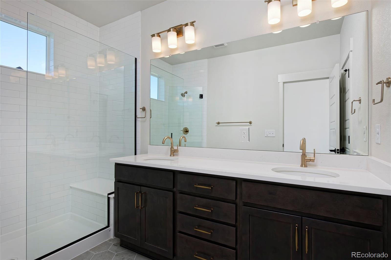3136 West Bonfils Place Denver, CO 80236 - Photo 33 of 43 a bathroom with a sink double vanity and a mirror