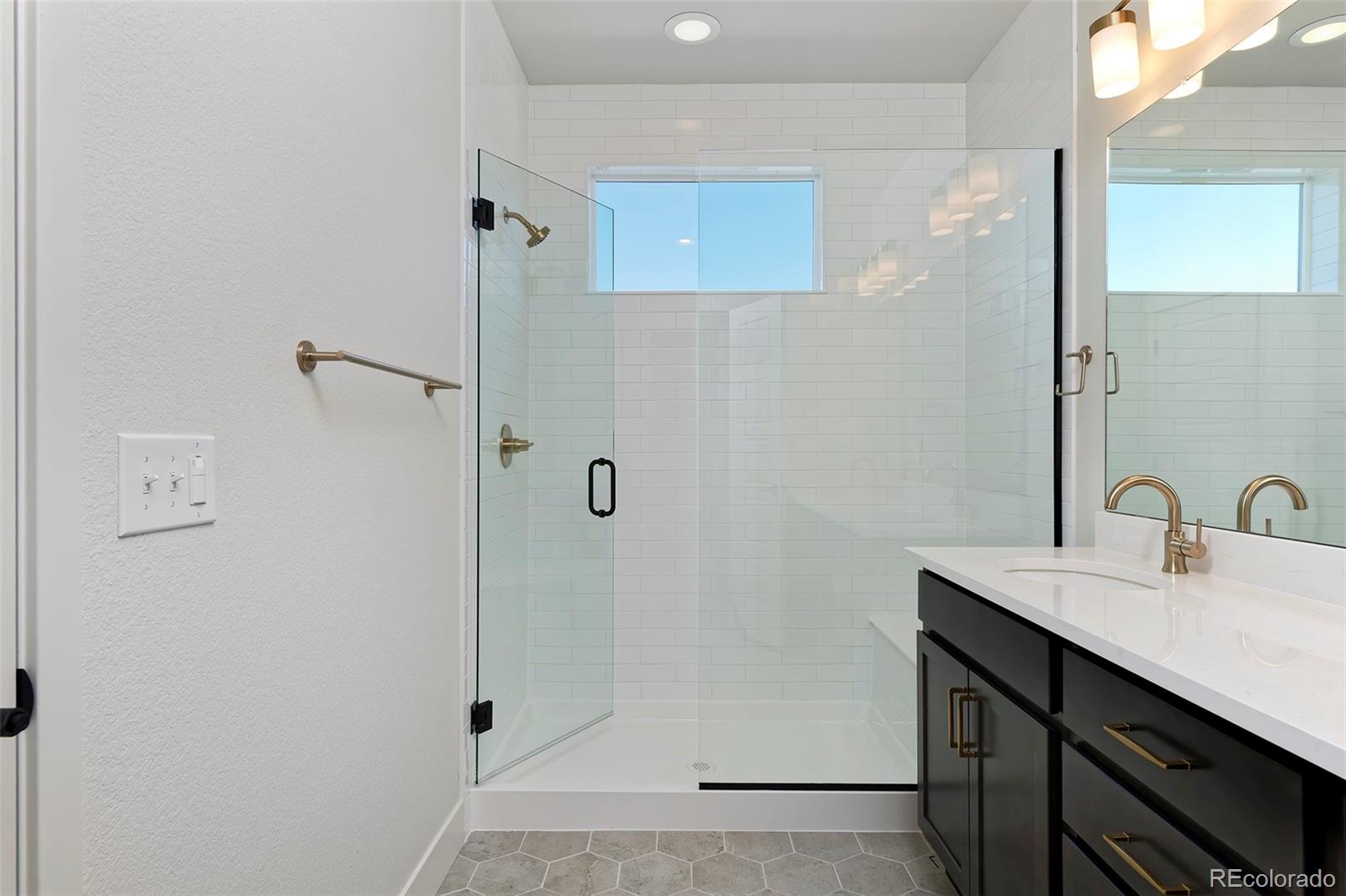 3136 West Bonfils Place Denver, CO 80236 - Photo 34 of 43 a bathroom with a sink mirror and shower