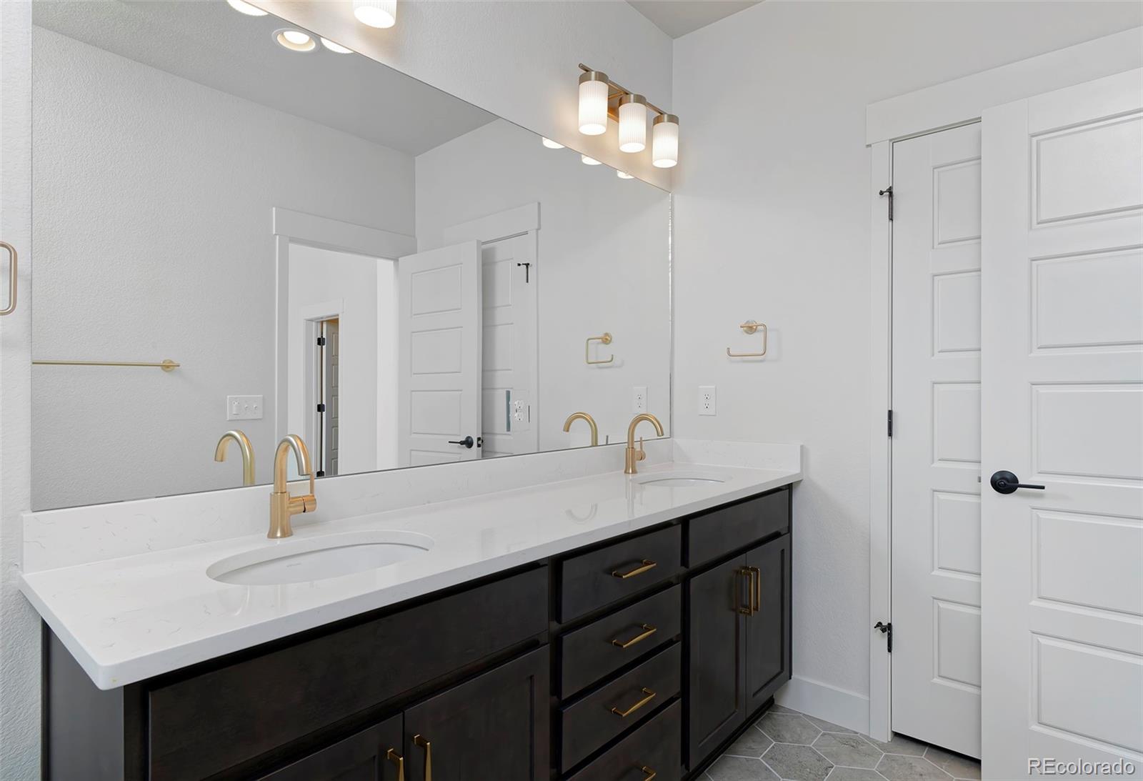 3136 West Bonfils Place Denver, CO 80236 - Photo 35 of 43 a bathroom with double sink and a mirror