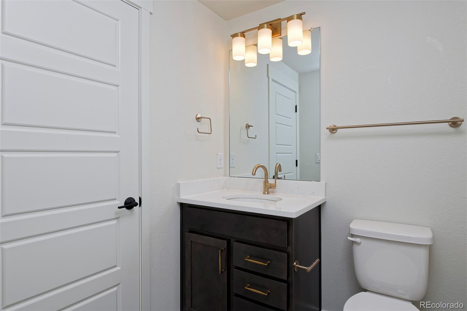 3136 West Bonfils Place Denver, CO 80236 - Photo 41 of 43 a bathroom with a sink toilet vanity and tub
