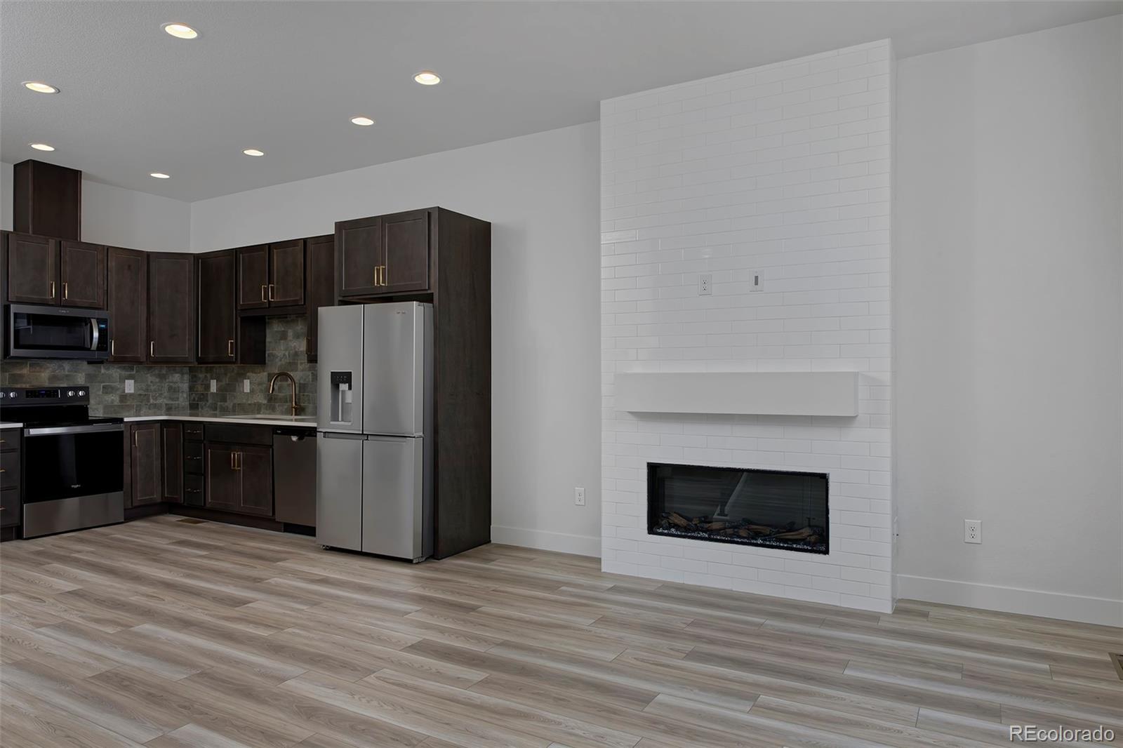 3136 West Bonfils Place Denver, CO 80236 - Photo 10 of 43 a kitchen with stainless steel appliances granite countertop a refrigerator and a stove top oven