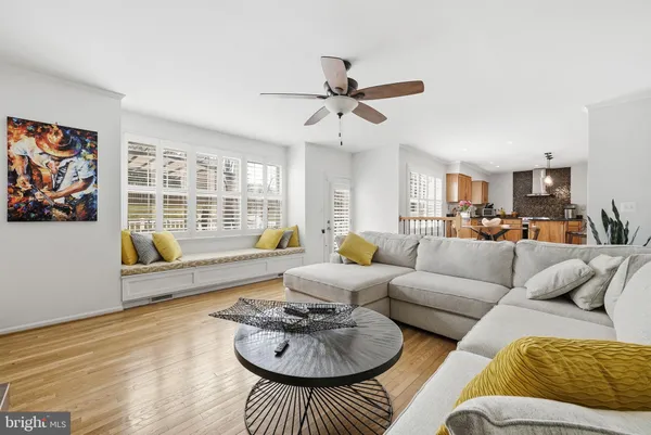 a living room with furniture kitchen view and a window