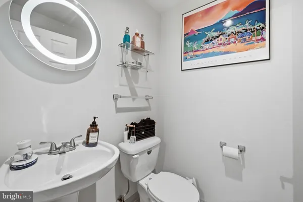 a bathroom with a toilet a sink and mirror