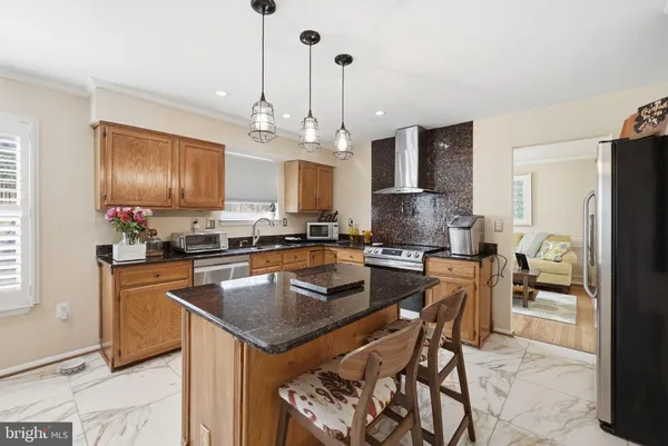 a kitchen with granite countertop kitchen island stainless steel appliances a refrigerator a stove a sink a center island and furniture