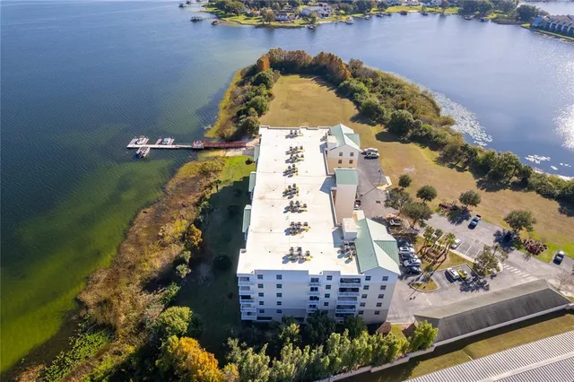 an aerial view of a house with a yard and lake view