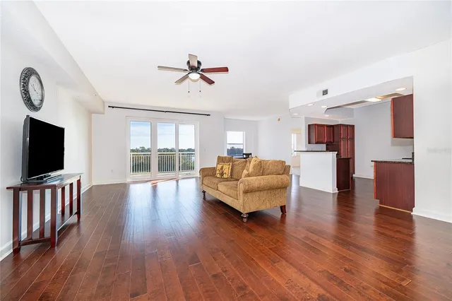 a living room with furniture wooden floor and a flat screen tv