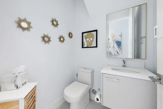 a bathroom with a toilet sink and mirror