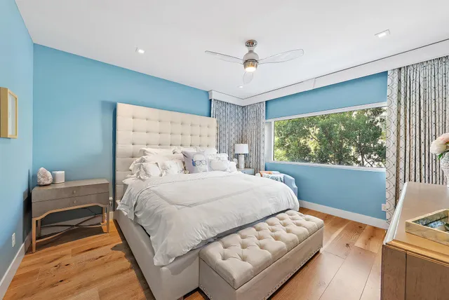 a bedroom with a bed and a large window