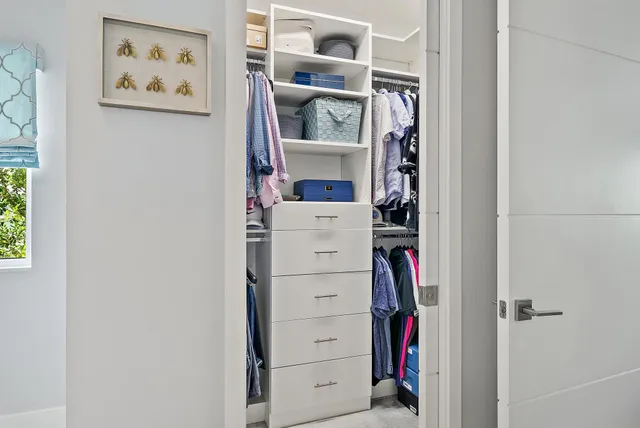 a view of walk in closet with clothes and shoes